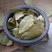 A white bowl filled with Regal Bay Leaves.