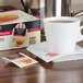 A cup of tea on a saucer with a Bigelow Ceylon Tea bag next to a box of Bigelow Ceylon Tea.