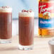 Two glasses of coffee with Torani hazelnut flavoring, whipped cream, and hazelnuts.