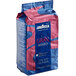A blue and pink bag of Lavazza Gran Riserva whole bean espresso coffee on a white background.