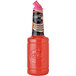 A bottle of red Finest Call Premium Grapefruit Sour Mix with a pink lid.
