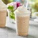 A close up of a cup of Capora Vanilla Latte / Frappe mix with whipped cream and a straw.