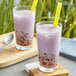 Two glasses of purple Fanale Taro milk with straws on a table.