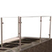 A stainless steel bar with a glass Advance Tabco cooking and carving food shield on a counter.