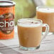 A glass mug of brown David Rio Tiger Spice Chai tea on a table.