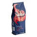 A blue and red Lavazza Classico ground coffee bag with a woman in the background.