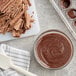 A bowl of melted Callebaut milk chocolate next to a white spatula.