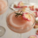 A glass of pink Finest Call Frose mix with a rose on top.