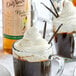 A glass mug of coffee with whipped cream and DaVinci Gourmet Madagascar Vanilla syrup.