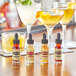 A table with several bottles of Scrappy's Bitters next to glasses of liquid.
