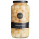 A jar of Belosa white pearl cocktail onions on a table with a black label.