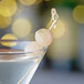 A martini garnished with two Belosa white pearl cocktail onions on a stick.