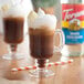 A glass of brown liquid with white foam made with Torani White Chocolate Flavoring Syrup.