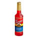 A close up of a Torani Ruby Red Grapefruit Flavoring Syrup bottle filled with red liquid.