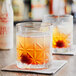 A close up of two glasses of a cherry drink with Fee Brothers Cherry Bitters on a table.