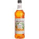 A close up of a Monin Premium Candied Orange Fruit Syrup bottle.