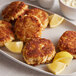 A plate of J.O. Crab Cakes with lemon wedges.
