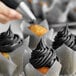 A close up of cupcakes with black frosting using Chefmaster Coal Black food coloring.