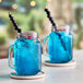 Two mason jars filled with blue Tiki Energy drinks.