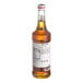 A bottle of Monin Macadamia Nut flavoring syrup with a white label.