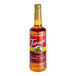 A close up of a Torani Almond Roca Flavoring Syrup bottle filled with brown liquid.
