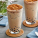 Two glasses of brown Fanale Tiramisu bubble tea with brown toppings and black bubbles.