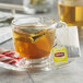 A glass cup of Lipton peppermint herbal tea with a tea bag in it.