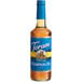 A Torani Sugar-Free Pumpkin Pie flavoring syrup in a glass bottle with a blue label.