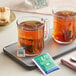 A tray with a couple of glass mugs of Bromley decaffeinated hot tea and tea bags.