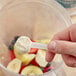 A hand holding a scoop of Add A Scoop protein powder.