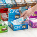 A hand holding a package of ONE Cookies and Creme Protein Bars.