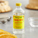 A bottle of Shank's orange extract on a counter next to a cake.