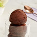 A close-up of a scoop of Oringer brownie batter ice cream in a glass.