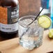 A glass of tonic water with ice and a lime slice on a table.