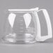 A clear glass coffee carafe with a white handle.