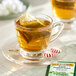 A glass of Twinings Pure Peppermint Herbal Tea with a tea bag in it.