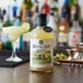 A bottle of Agalima Organic Margarita Mix on a bar counter.