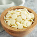 A wooden bowl filled with Cacao Barry white chocolate pistoles.