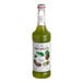 A green Monin bottle of kiwi syrup with a white label.
