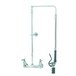 A T&S chrome wall mounted pre-rinse faucet with a swivel arm, hose, and low flow spray valve.