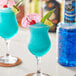 A blue drink made with Finest Call Blue Curacao syrup, fruit, and an umbrella.