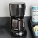 A Hamilton Beach black coffee maker on a counter.
