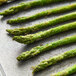 Asparagus spears on a baking sheet.