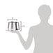 A woman holding a Hamilton Beach stainless steel coffee carafe.