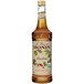 A Monin Organic Hazelnut flavoring syrup bottle with a label containing brown liquid.