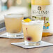 Two glasses of Agalima sweet and sour mix drinks with fruit on top on a table.