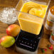 A blender with a container of yellow Smartfruit Mellow Mango Puree in it.