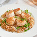 A plate of food with scallops and rice topped with Nielsen-Massey Indonesian Vanilla Extract.