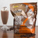 A bag of DaVinci Gourmet Iced Coffee Mix next to a glass of chocolate milkshake.