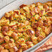 A white casserole dish of bread stuffing with Regal Ground Savory Leaves.